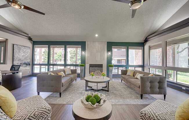 A living room with a grey couch, a coffee table, and a ceiling fan.