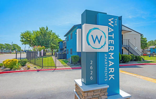 a blue and white sign is sitting in front of a building