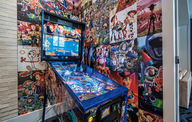 a pinball machine in front of a wall covered in anime pictures at Altis Santa Barbara, Naples, FL