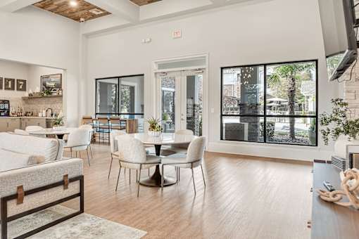 A modern dining room with a glass door leading to a balcony.