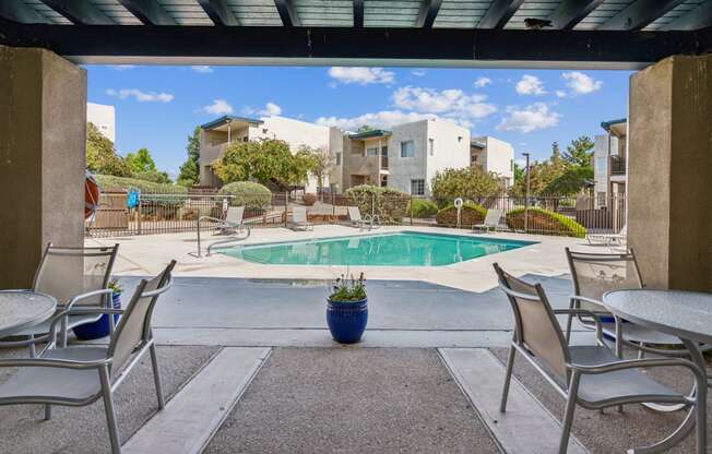 our apartments have a pool and patio with chairs and tables