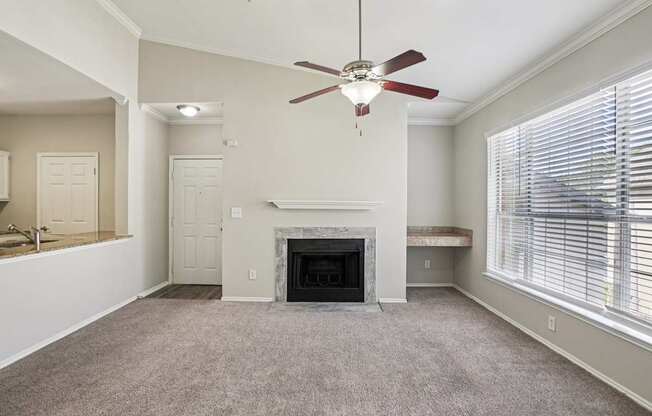 A living room with a fireplace and a ceiling fan.