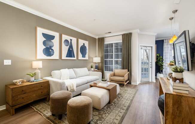 A living room with a white couch, a wooden dresser, and a rug.