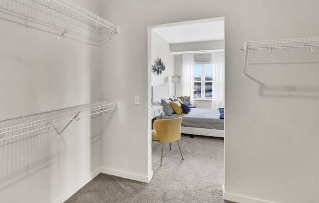 a bedroom with a closet and two hanging racks on the wall