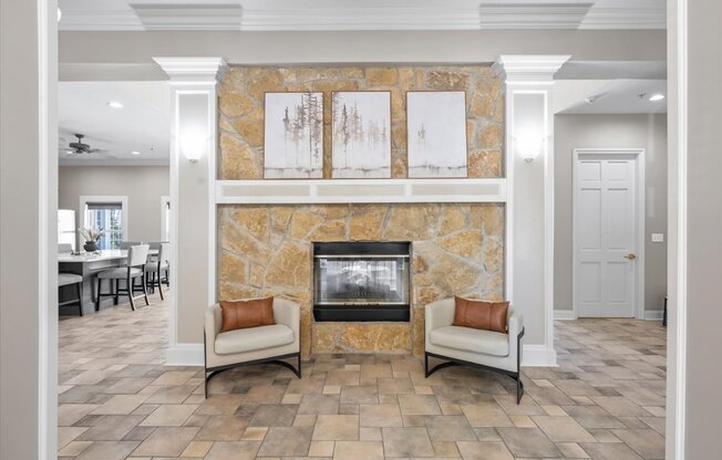 A living room with a stone fireplace and two chairs. at Somerset Oaks Apartment Homes, Olathe, KS