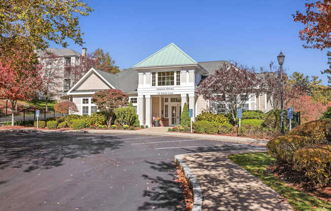 A large building with a green roof and a driveway in front.