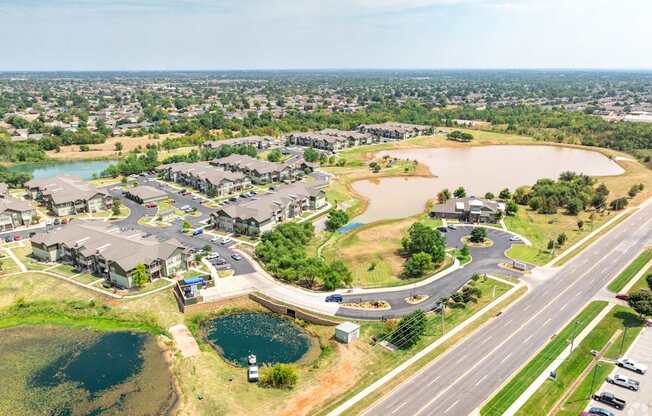 an aerial view of a community with a highway and a lake