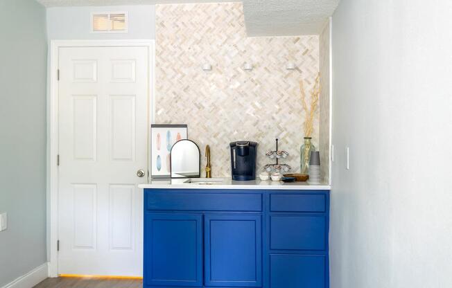 a kitchen with blue cabinets and a counter top and a white door