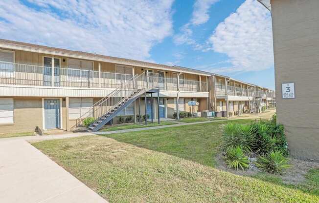 Apartment complex with a blue sky and clouds in the background at The Creole Apartments in Shreveport, LA
