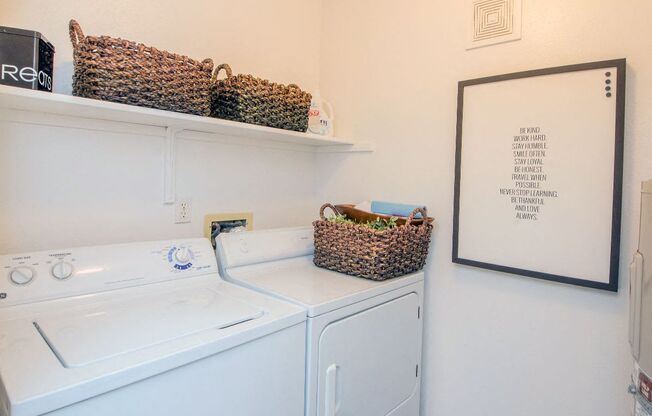 a white washer and dryer in a laundry room with baskets