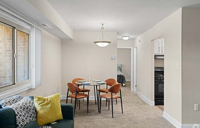 A dining room with a table set for four.