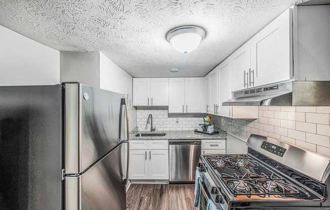 a kitchen with stainless steel appliances and white cabinets