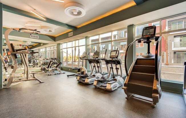 A gym with treadmills, elliptical machines, and other exercise equipment.