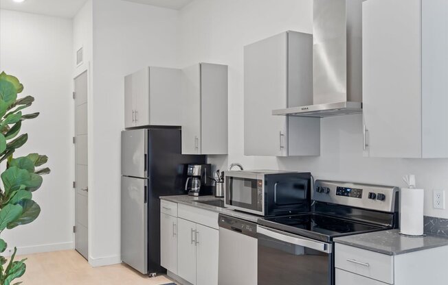 A modern kitchen with a black refrigerator and stove.