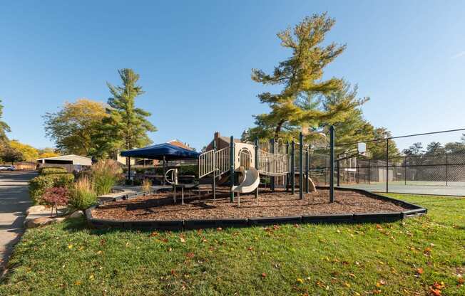 a playground with a slide and a swing set in a park