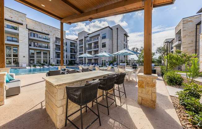 A patio with a table and chairs is surrounded by buildings.