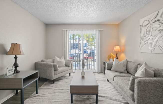 a living room with couches and a coffee table and a balcony