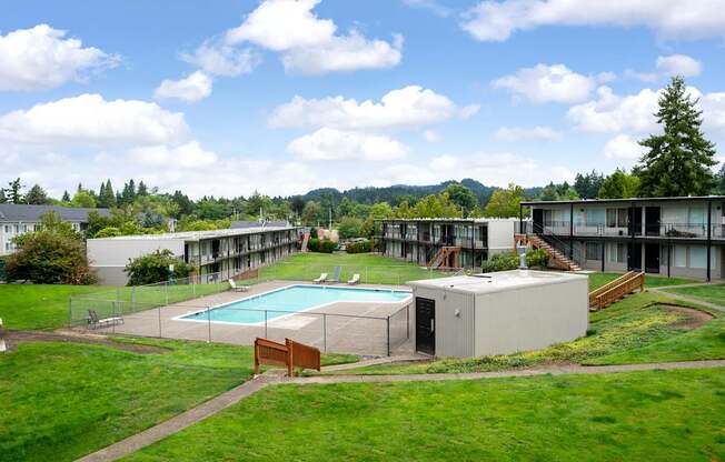 A large building complex with a pool in the foreground.