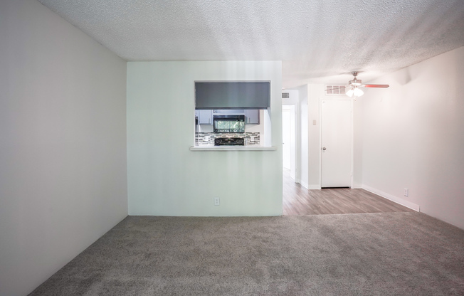 Carpeted living room and kitchen bar at Treehouse Apartments in Albuquerque, New Mexico
