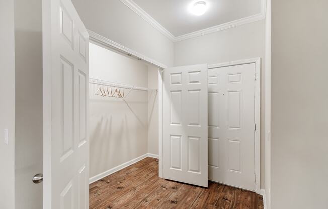 a walk in closet in a home with white walls and wood floors at Cumberland Place Apartment Homes, Tyler