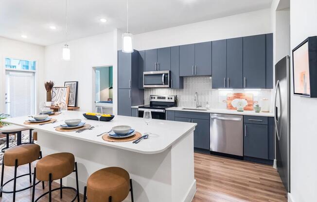 Indulge in culinary delights within Modera Garden Oaks' gourmet kitchens, highlighted by quartz countertops and custom 42-inch cabinetry featuring under-cabinet lighting for both style and practicality.