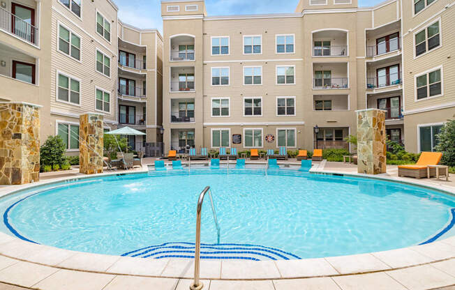 a swimming pool with an apartment building in the background