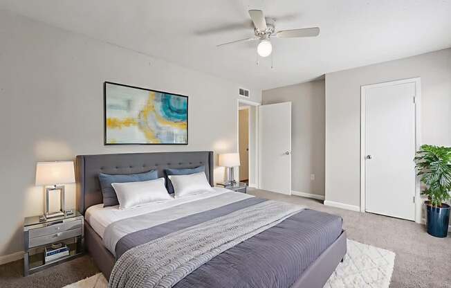 A bedroom with a large bed and a ceiling fan.