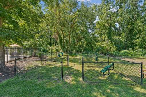A park with a green bench and a fence at Staples Mill Townhomes Apartments, Richmond