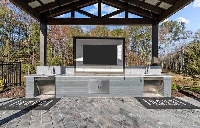 A modern outdoor entertainment area with a television and seating.