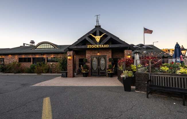 the facade of The Stockyard  restaurant with a flag at dusk