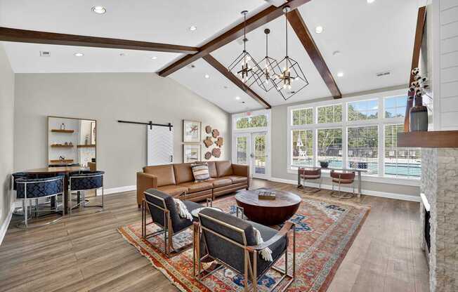 Community room with high ceilings, sofas and chairs, and large windows overlooking the pool