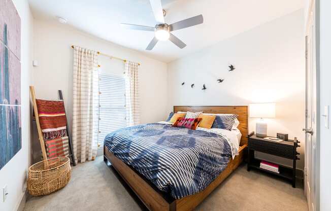 Lenox SoCo Apartments  bedroom with a bed and a ceiling fan