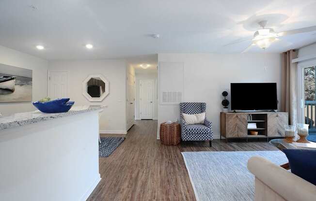 A living room with a white fireplace, a blue chair, and a television.
