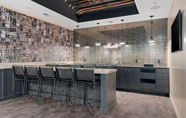 a bar with stools in front of a brick wall with a tv on it at The Lodge at Overland, Rochester, MN