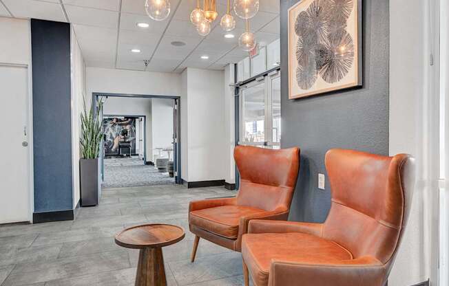 Two brown leather chairs and a table in a room.