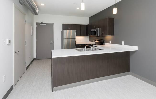 Modern open-concept kitchen and living area with stainless steel appliances.