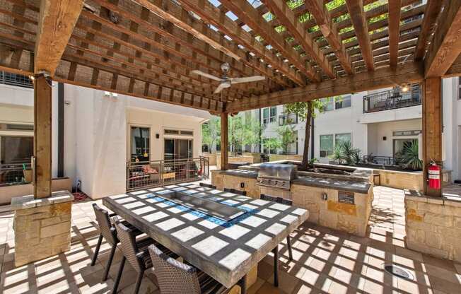 a patio with a table and a grill