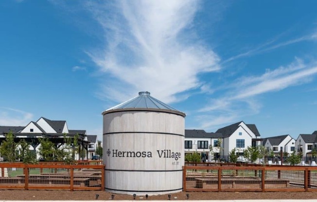 a grain silo sits in front of a row of houses