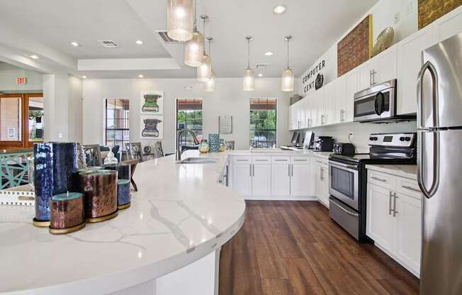 A modern kitchen with white cabinets and a wooden floor.