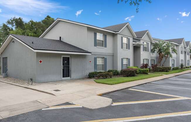 a white house with a street and a parking lot