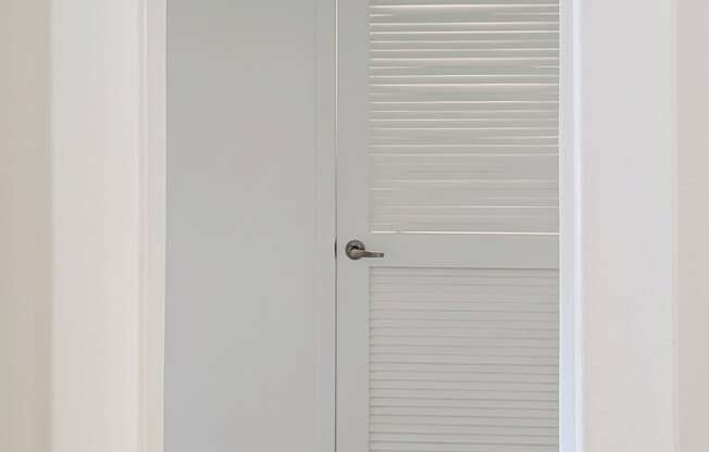 A white door with a silver handle is closed.