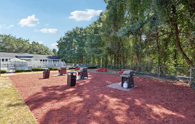 A park with a red surface and a fence.