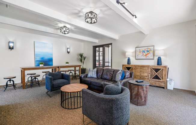 a living room with couches and chairs and a desk