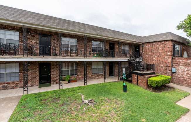 A brick building with a green lawn in front.