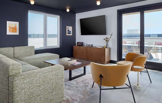 A living room with a grey couch, a yellow chair and a brown cabinet.