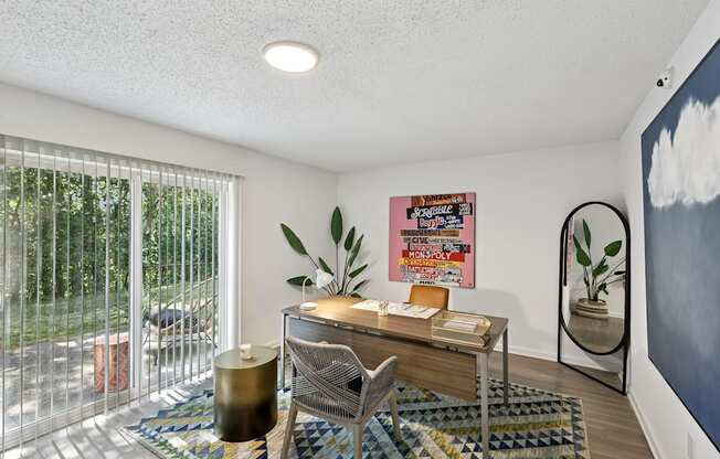 A room with a desk, chair, and a poster on the wall.