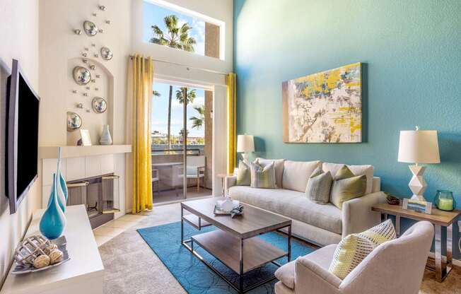 A living room with a white sofa, a grey armchair, a coffee table, a television, and a painting on the wall.