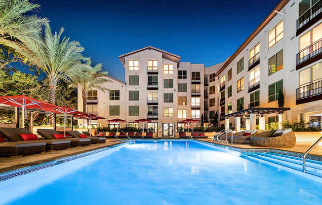 Poolside view at twilight with modern cabanas, plush loungers, and a serene atmosphere