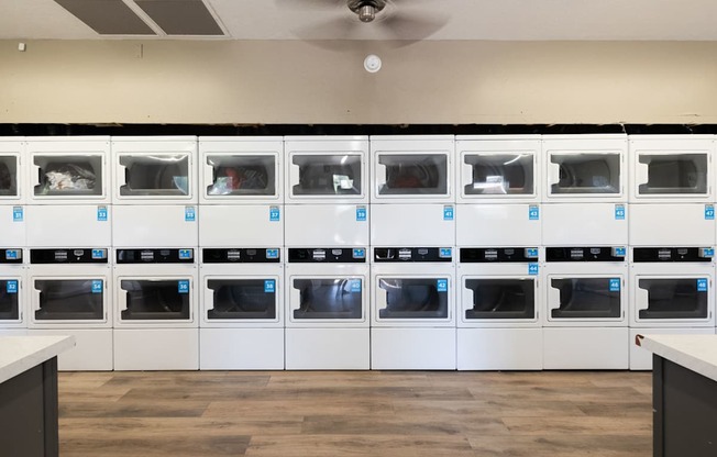the laundry room is full of white cabinets and appliances