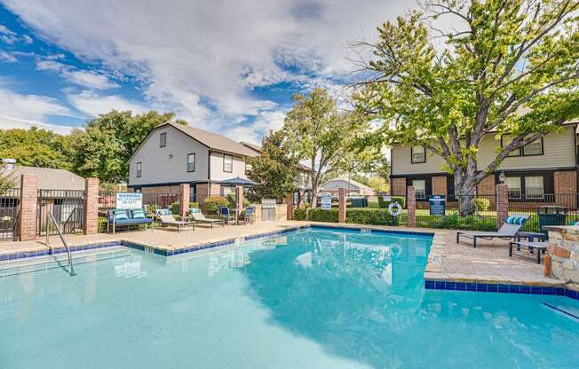 A swimming pool surrounded by a fence and trees.